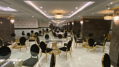 麦加فندق منار التوحيد 2的用餐室配有桌椅和吊灯。