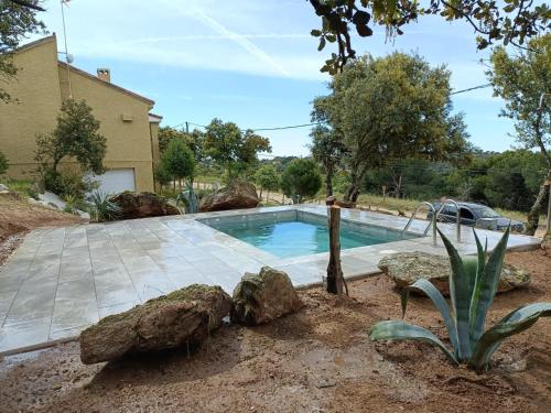 马德里El Escondite de La Caprichosa的一座位于岩石庭院内的游泳池