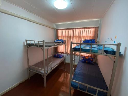 曼谷Sura Hostel and Coworking的带窗户的客房内的两张双层床