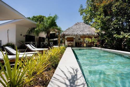 塔马林多Antema Lodge Secteur Tamarindo, piscine, yoga, gym, jungle et paix的一座带游泳池和度假村的别墅