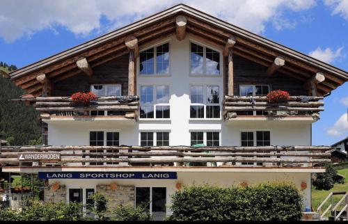 巴特欣德朗MOUNTAIN LODGE OBERJOCH, BAD HINDELANG - moderne Premium Wellness Apartments im Ski- und Wandergebiet Allgäu auf 1200m, Family owned, 2 Apartments mit Privat Sauna的一座白色的大建筑,设有木屋顶