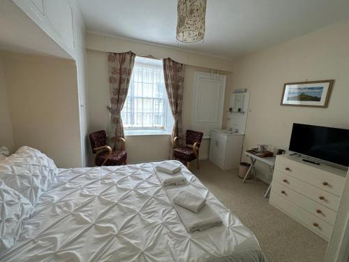 韦斯特贝The Durbeyfield Guest House的一间卧室配有一张床、梳妆台和电视。