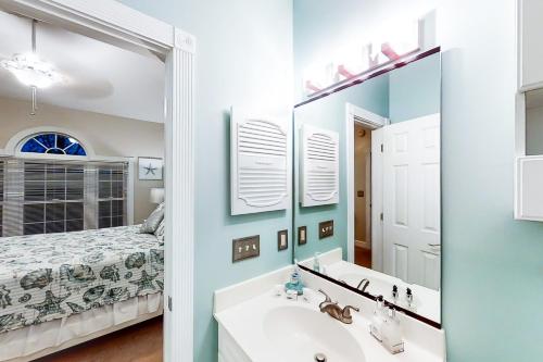 默特尔比奇Riverwalk 301的一间带水槽和镜子的浴室以及一张床