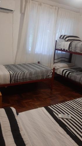 科尔多瓦Alojamiento Kempes的配有两张双层床的白色窗帘客房