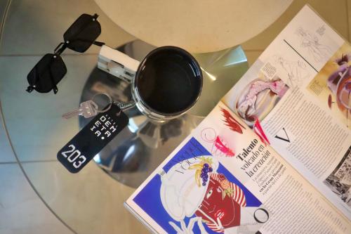 瓦努科Hotel Demetria的杯子和杂志上的玻璃桌