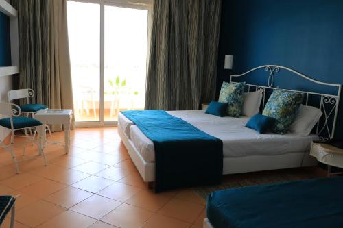 DjerbaHotel Riad Meninx Djerba的一间卧室设有一张蓝色墙壁的大床