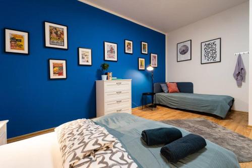 布尔诺Sauna Apartment - Brno(x) Cejl的一间卧室设有蓝色的墙壁、一张床和一个梳妆台