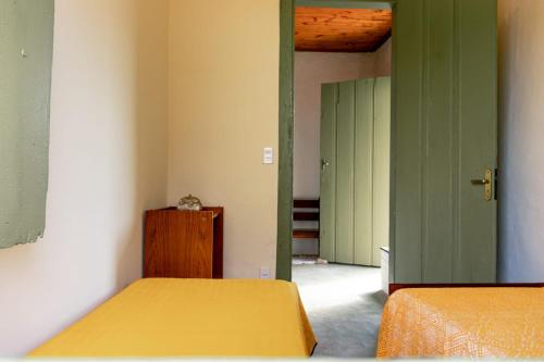 BocaiúvaCasa Maia的一间设有两张床的房间和一个带两扇门的走廊