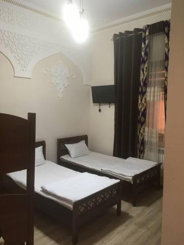 撒马尔罕Uzbek House的带窗户的客房内设有两张单人床。