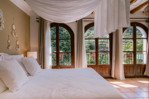 圣胡安包蒂斯塔Valley Club Ibiza - Boutique Agroturismo的卧室设有白色的床和大窗户