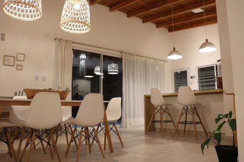 埃斯佩兰萨Quinta El Hornero的厨房配有白色椅子和厨房岛