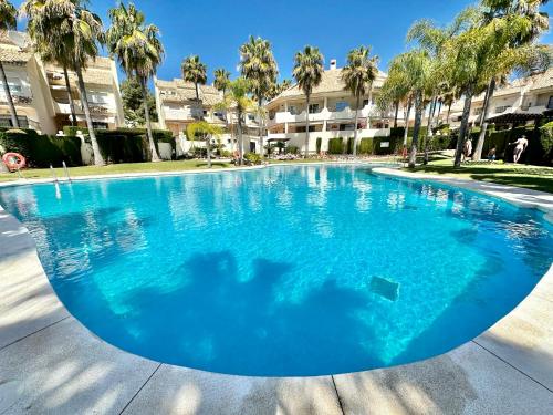 马贝拉El Arenal Townhouse By The Beach With Swimming Pool - EaW Homes的一个种有棕榈树的大型蓝色游泳池