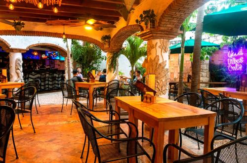 坎昆Mezcal Hostel的一间设有桌椅的餐厅,以及坐在里面的人