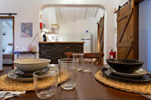 圣布拉什迪阿尔波特尔Casa da Soalheira的木桌,上面放着碗和玻璃杯
