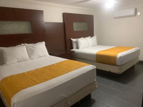 墨西卡利HOTEL DORADO DIAMANTE的一间酒店客房,房间内设有两张床