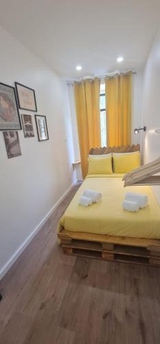 里斯本S.Soares Yellow Beato的一间卧室配有一张带两个枕头的大型黄色床