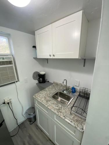 圣彼得堡Uptown Inn & Suites的厨房配有白色橱柜和水槽