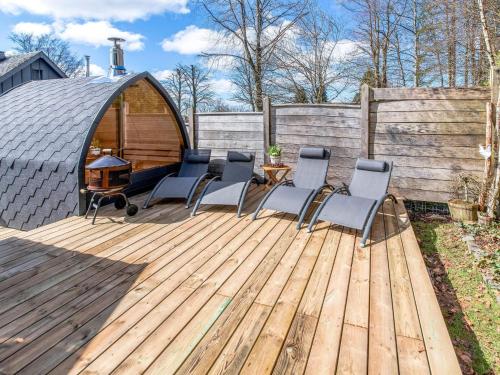 比林根Charming house with sauna and Nordic bath的一个带椅子的木制甲板和凉亭