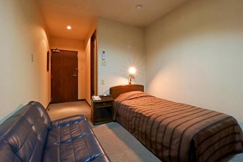 弘前市小堀旅馆的酒店客房,配有床和沙发