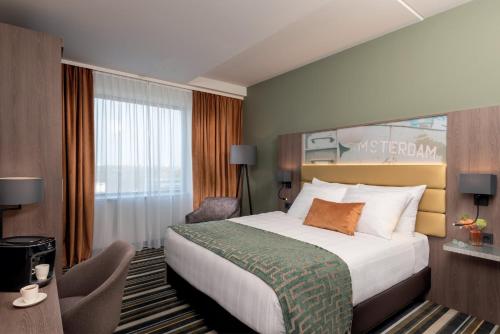 阿姆斯特丹Leonardo Royal Hotel Amsterdam的酒店客房设有床和窗户。