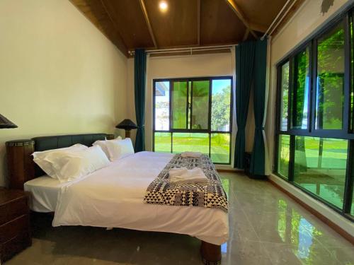 Sigatokacoral coast FIJI的一间卧室配有一张带白色床单和窗户的床。