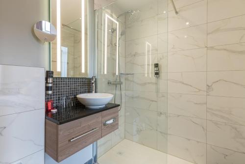 安特卫普莱昂纳多酒店安特卫普酒店的一间带水槽和淋浴的浴室