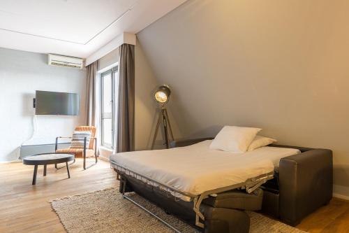 莱利斯塔德Leonardo Hotel Lelystad City Center的卧室配有1张床、1张桌子和1把椅子