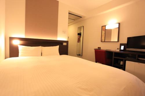 京都京都城市酒店的酒店客房设有白色的床和电视。