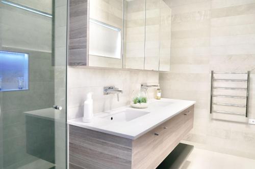金德拜恩Pinecone Lodge的浴室配有白色水槽和淋浴。