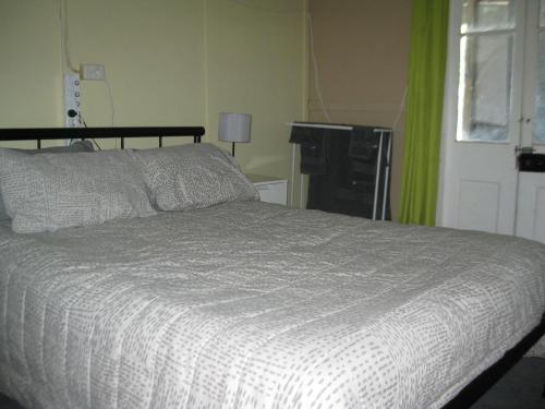 温顿Australian Hotel Winton Budget Hotel Accommodation的卧室配有带白色棉被的床
