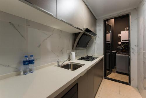 深圳WSSU 微宿精品公寓-深圳大学城塘朗地铁站店的厨房配有水槽和台面