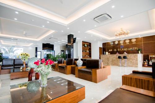 下龙湾Hạ Long Land Hotel的大堂配有沙发和鲜花桌