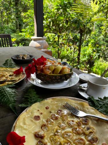 武吉拉旺Happy Ria Homestay & Guesthouse的餐桌上放着盘子和馅饼