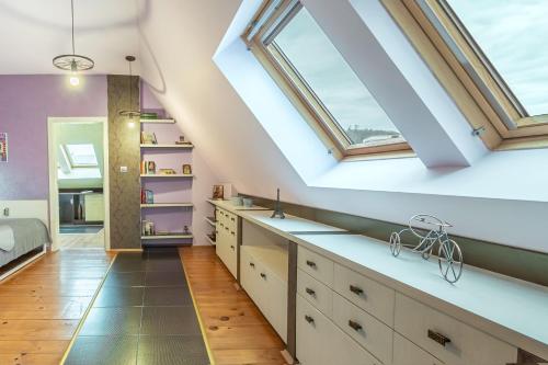 普罗夫迪夫Zen Home pLOVEdiv的阁楼厨房设有天窗和白色橱柜。