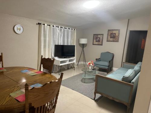 坦帕Oak Ridge House的客厅配有桌子、沙发和电视
