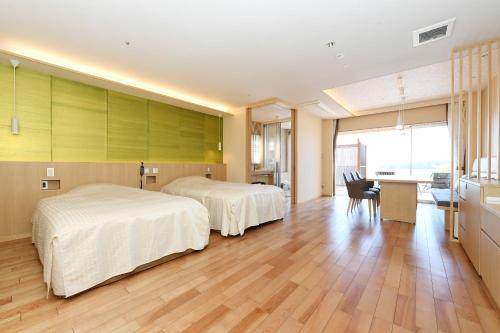 下田下田大和旅馆的酒店客房配有两张床和一张书桌