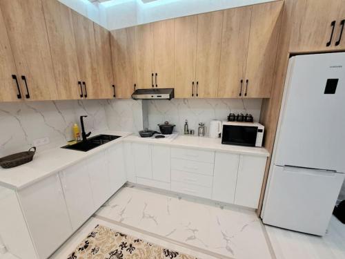 杜尚别Apartment in City Center的厨房配有白色橱柜和白色冰箱。