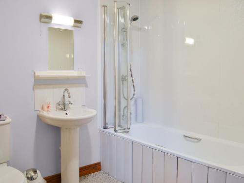 Aber-Brân查尔格罗夫度假屋的白色的浴室设有水槽和淋浴。