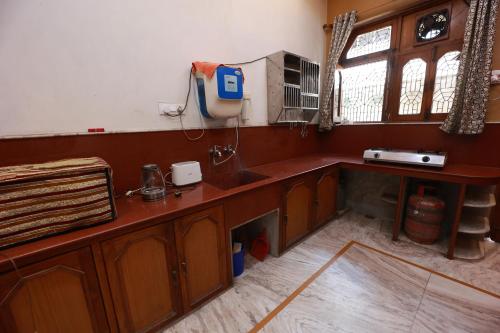 瓦拉纳西Kapoor Sahab Homestay : it's a home away from home.的厨房配有木制橱柜、水槽和窗户。