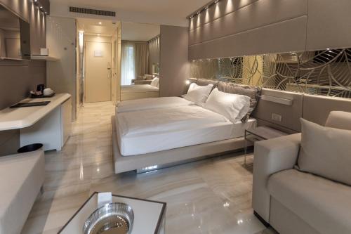 利莫内-苏尔加达帝国公园酒店的一间卧室配有一张床,客厅配有沙发
