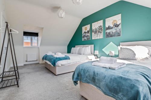 北安普敦Beautiful and Comfortable Home away from Home的一间卧室设有两张床和绿色的墙壁