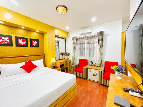 河内Moon Hotel Cau Giay的一间卧室配有一张床、一张桌子和红色椅子