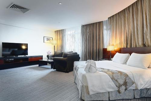 哥打京那巴鲁六十三酒店的酒店客房,配有床和电视