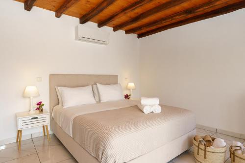 伊兹拉Villa Maria - Hydra Dream Houses的一间白色卧室,配有床和床头柜