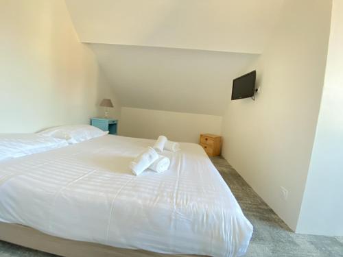 波尔尼谢Hotel et Studios Le Marina Baie de La Baule的卧室配有白色床和毛巾
