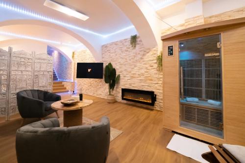 特鲁瓦Le Spa de la Cathédrale - Jacuzzi - Sauna - Champagne - Netflix - Wifi的客厅配有两把椅子和壁炉
