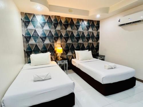 曼谷Bed by Tha-Pra SHA Plus的一间卧室设有两张床和一堵墙