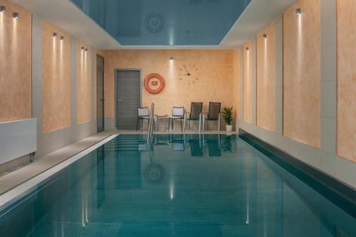 卡罗维发利Spa Hotel Villa Smetana的大楼内一个带桌椅的游泳池