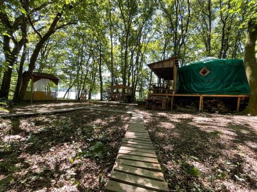 MiélanHebergement insolite, Location Yourte au bord du lac de mielan的营地,设有帐篷和木制走道