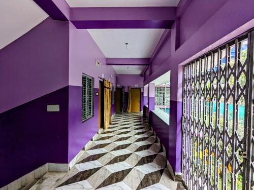 PurbbadulkiSundarban Tulip Homestay, Pakhiralay, WB的紫色墙壁房子的走廊